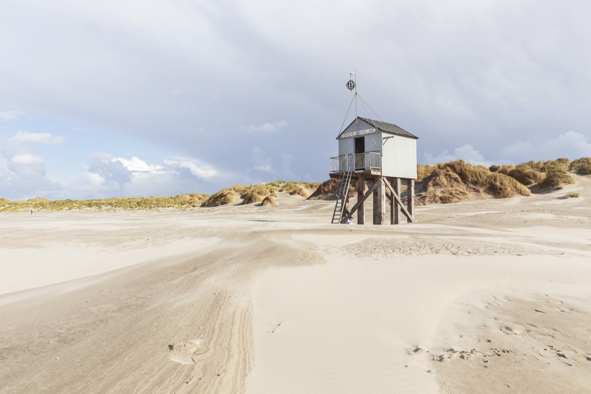 Uitzicht op het drenkelingenhuisje op het Noordzeestrand van Terschelling, omringd door duinen.