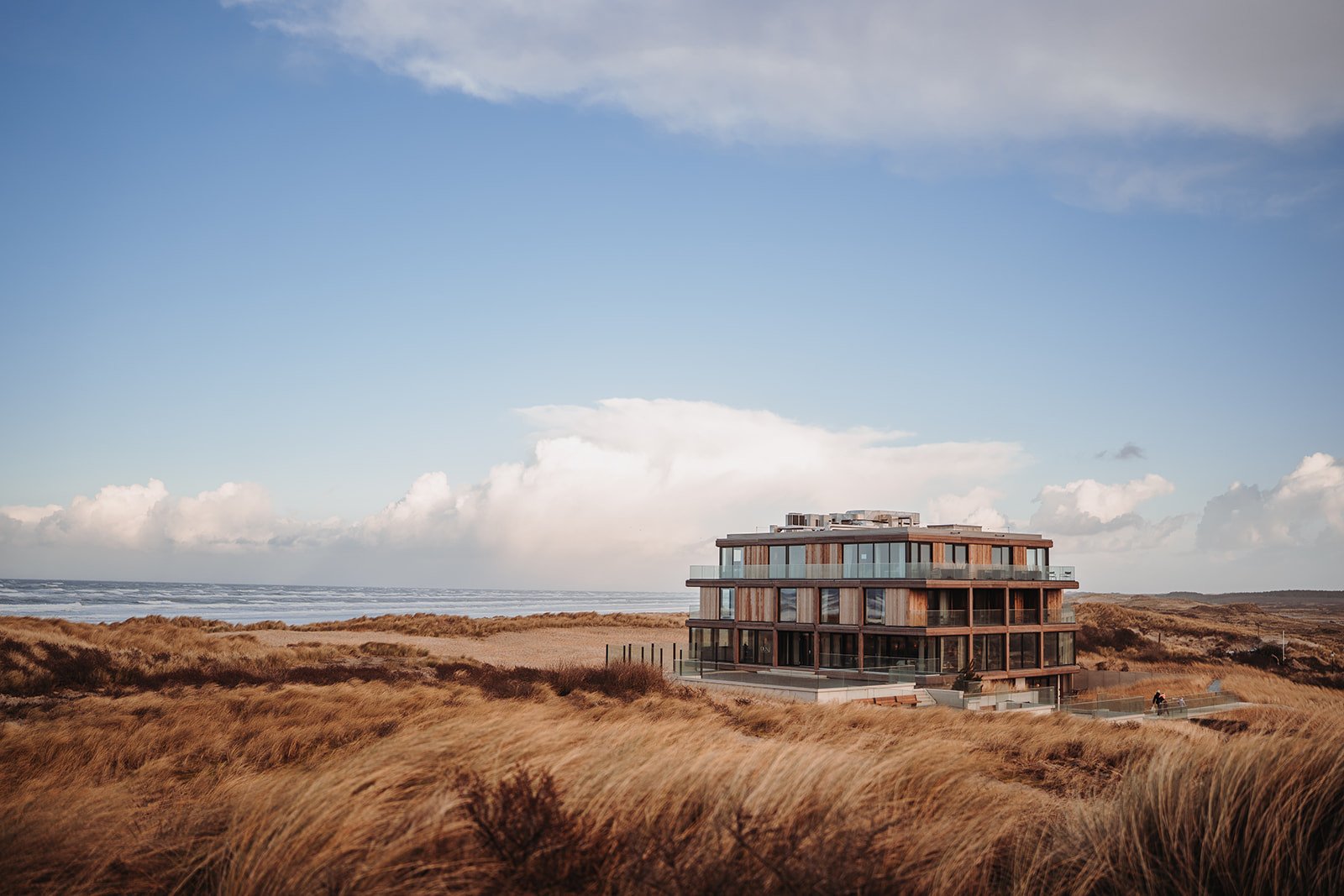 Exterieurbeeld van Elements Terschelling. Het glooiende landschap en uitgestrekte duinen van Terschelling, met de Noordzee op de achtergrond.