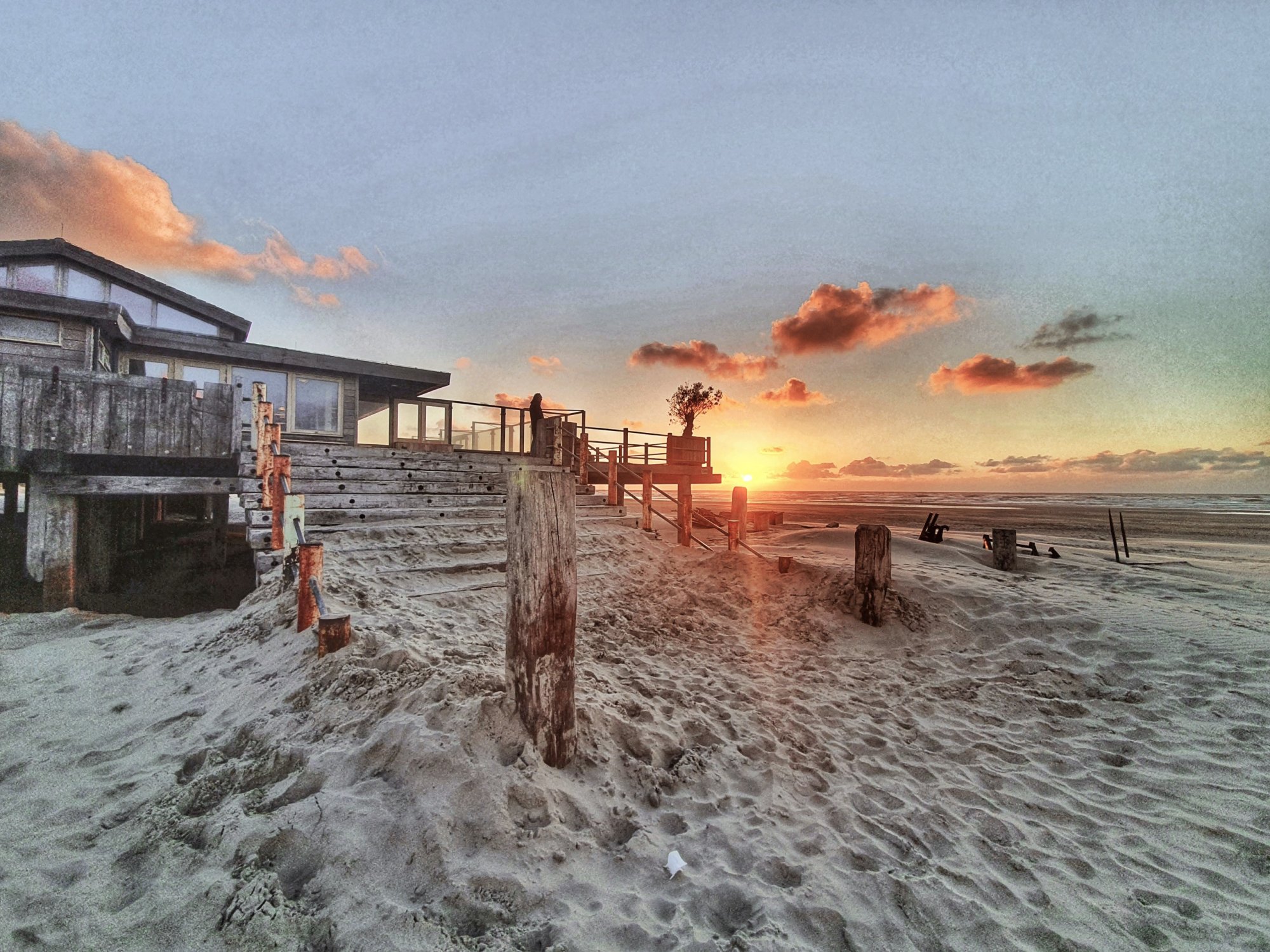 Zonsondergang bij strandpaviljoen op het strand van West aan Zee, Terschelling.