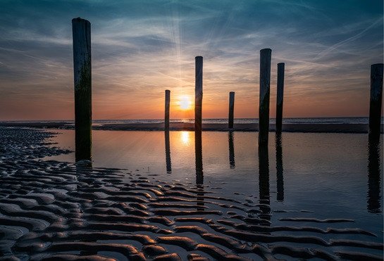 Strand en zee bij Petten aan Zee, kustlandschap aan de Noordzee bij zonsondergang.