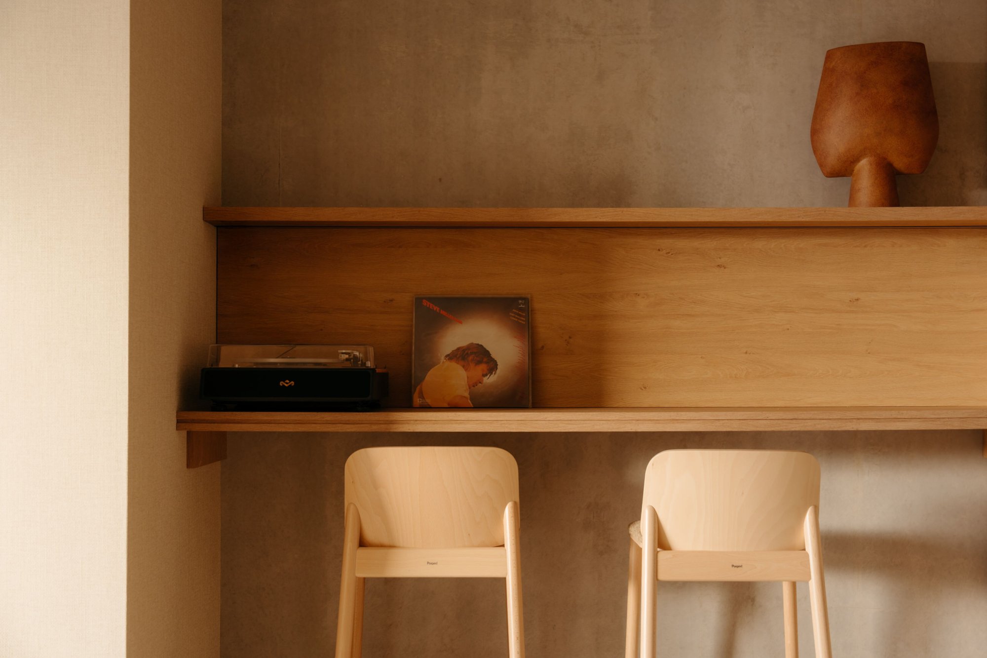 Stijlvolle houten eetbar met krukken in warm ingericht appartement op Terschelling.