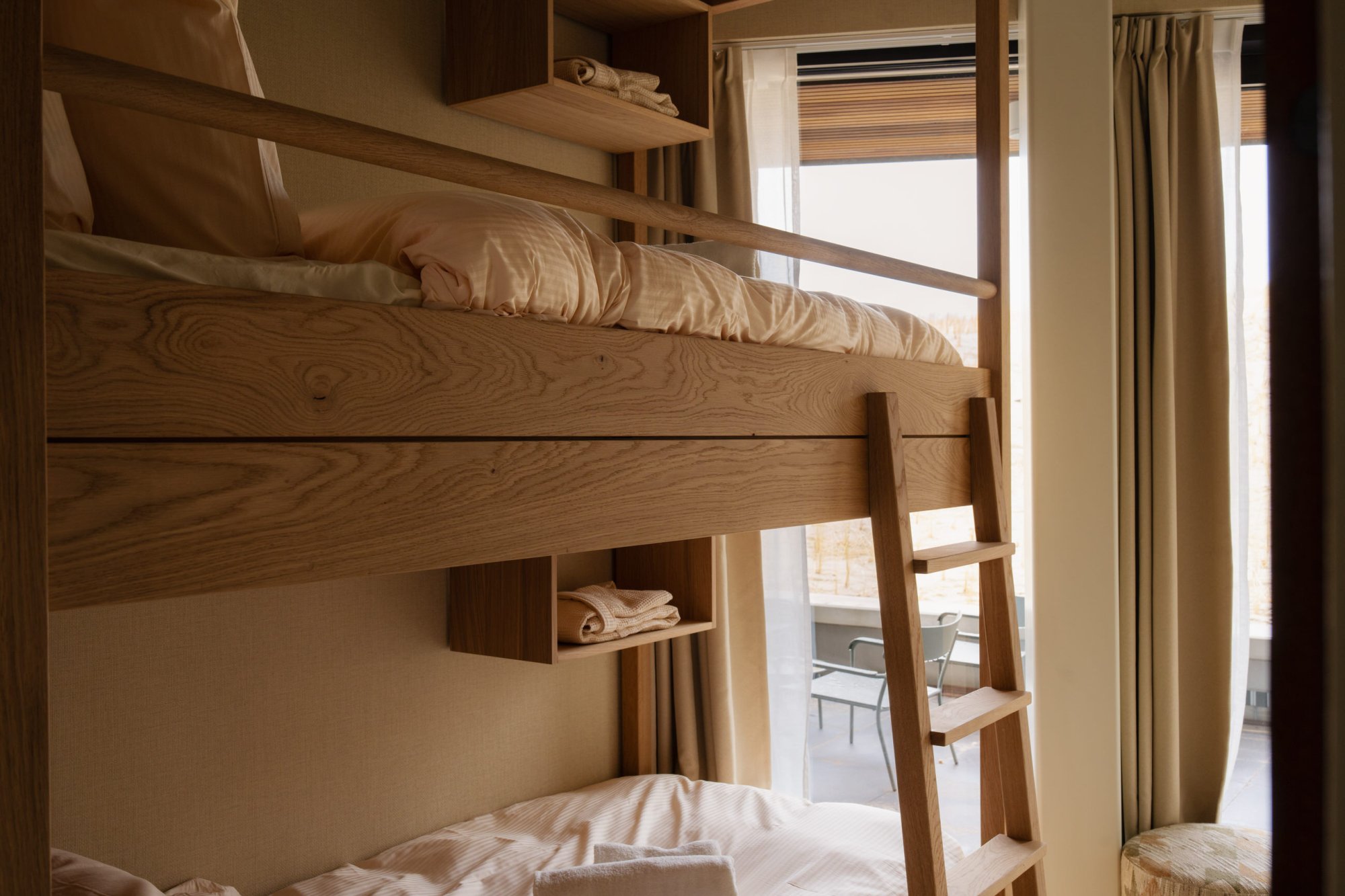 Slim ingedeelde slaapruimte met stapelbed in luxe appartement.