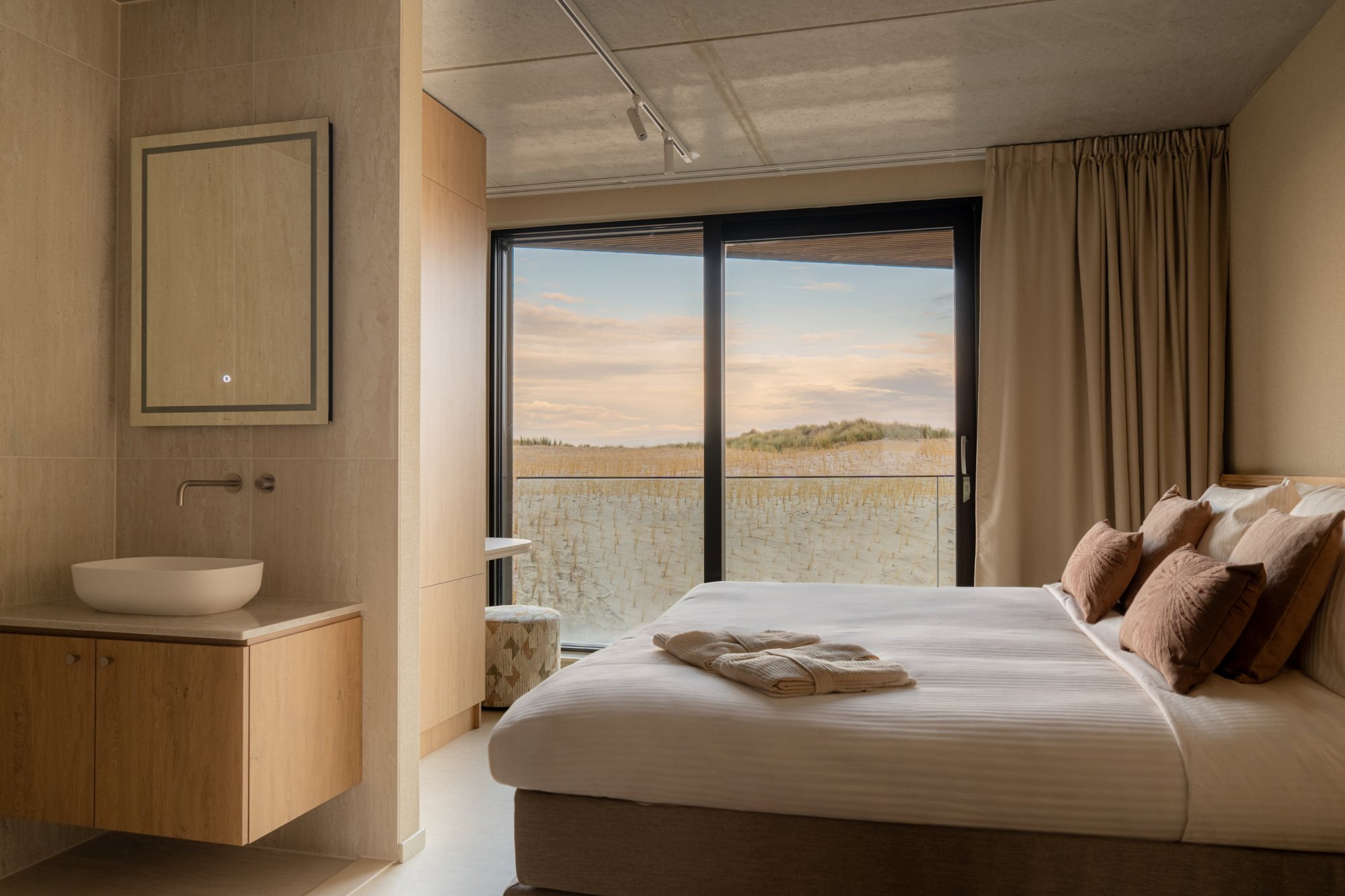 Luxe slaapkamer met uitzicht op duinlandschap bij Elements Terschelling.