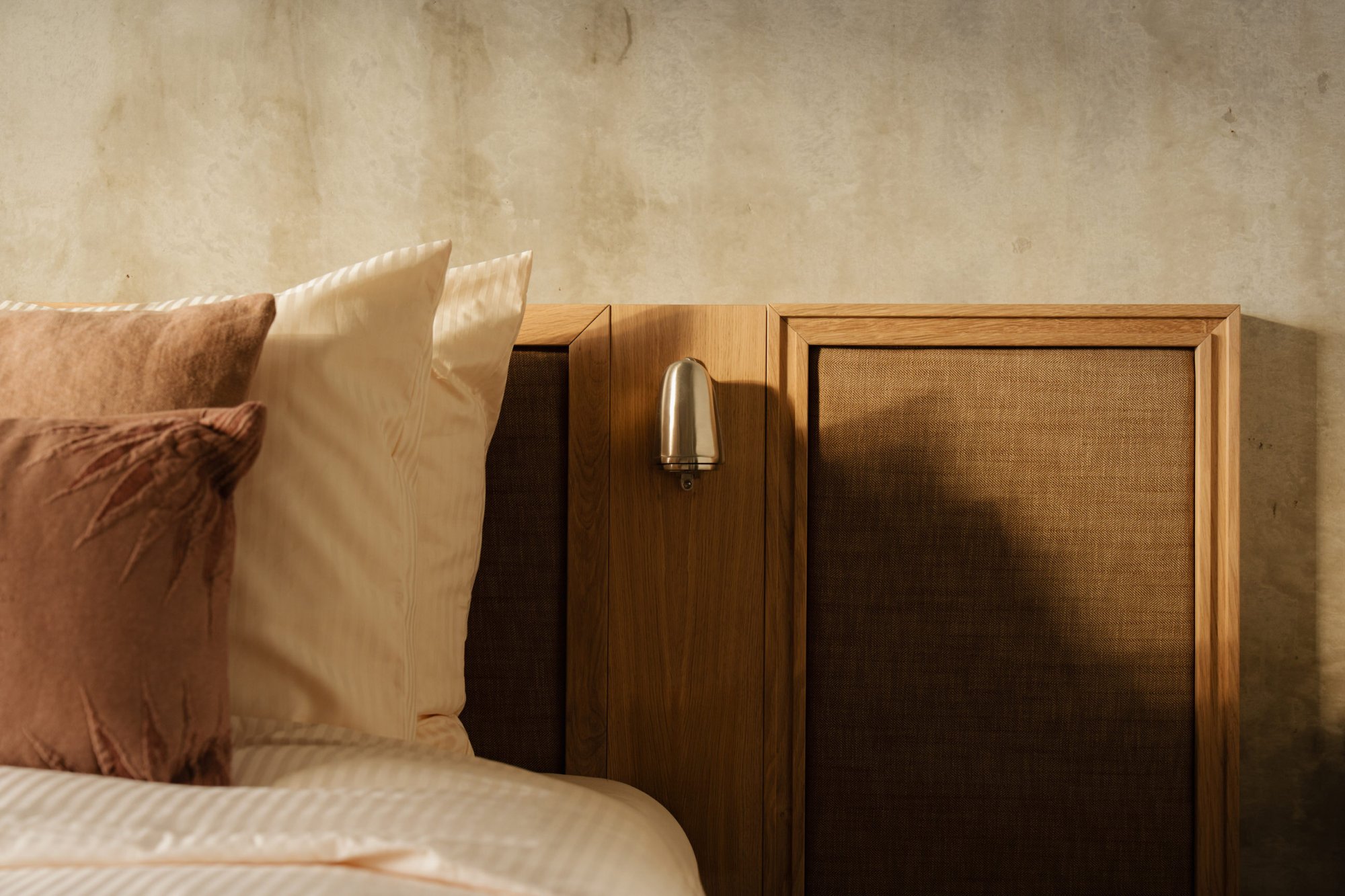 Zachte bedtextiel en natuurlijke materialen in Elements appartement.