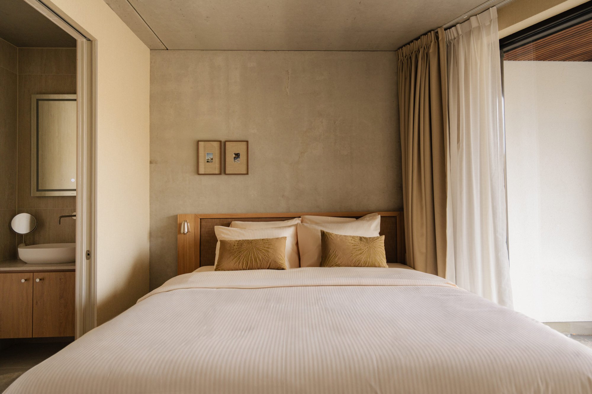 Rustige slaapkamer met luxe bed en zachte tinten.