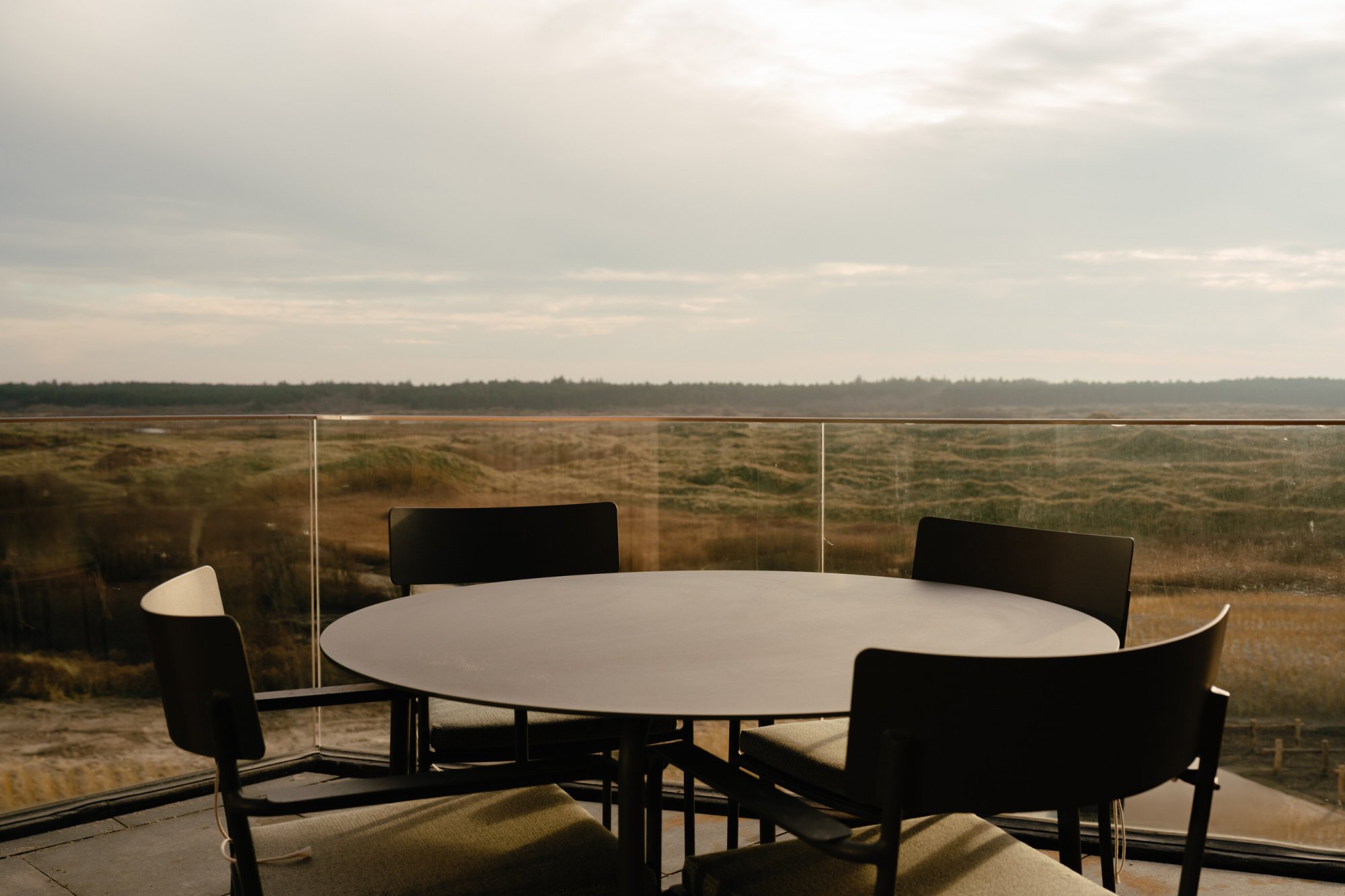Terras met uitzicht op duinen en zee bij duplex appartement op de bovenste verdieping.