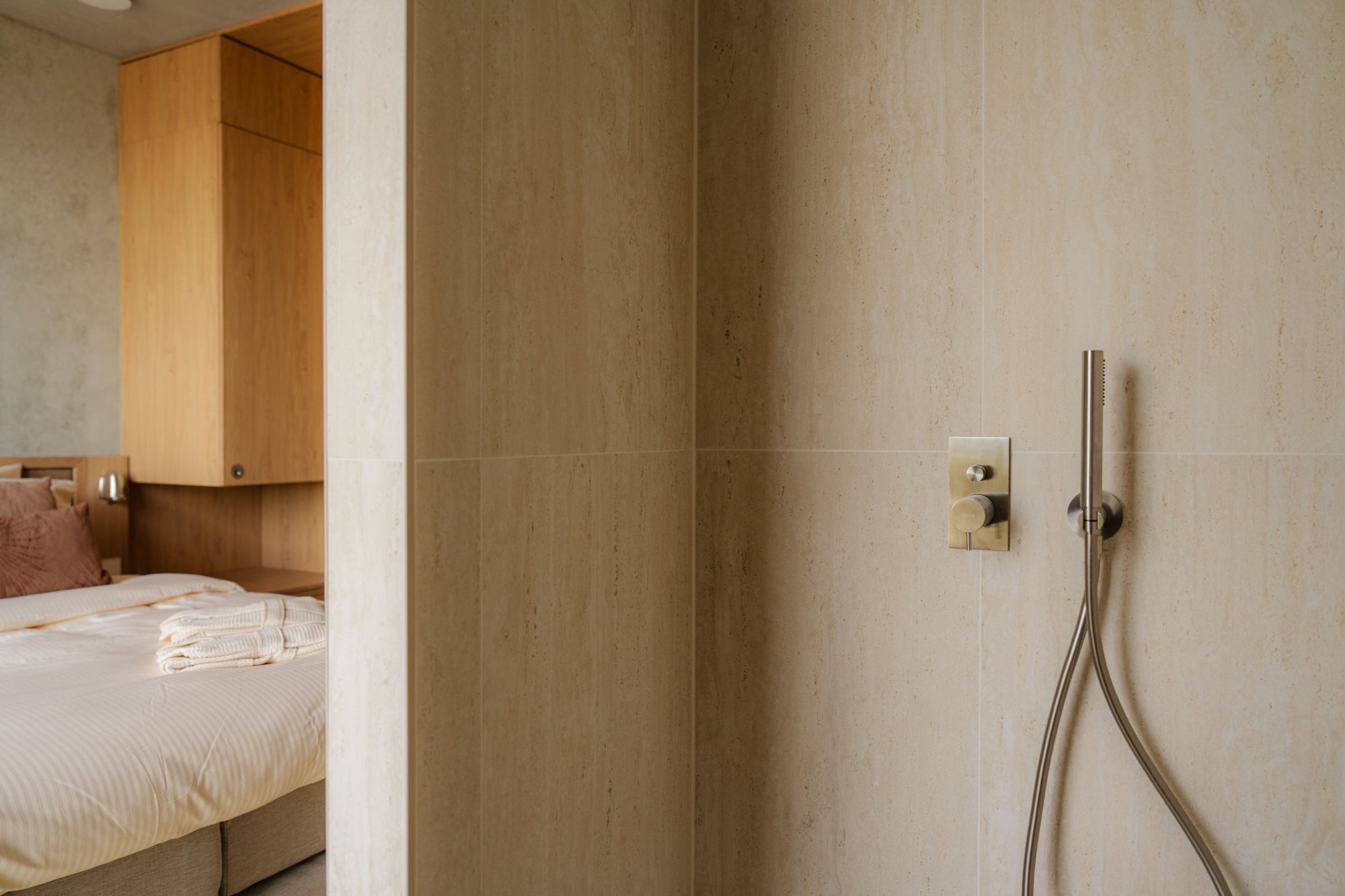 Slaapkamer met tweepersoonsbed en natuurlijke materialen in duplex appartement.