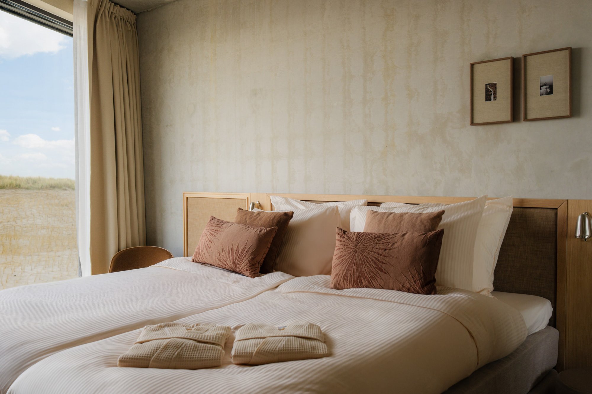 Slaapkamer met groot raam en uitzicht op de natuur van Terschelling.