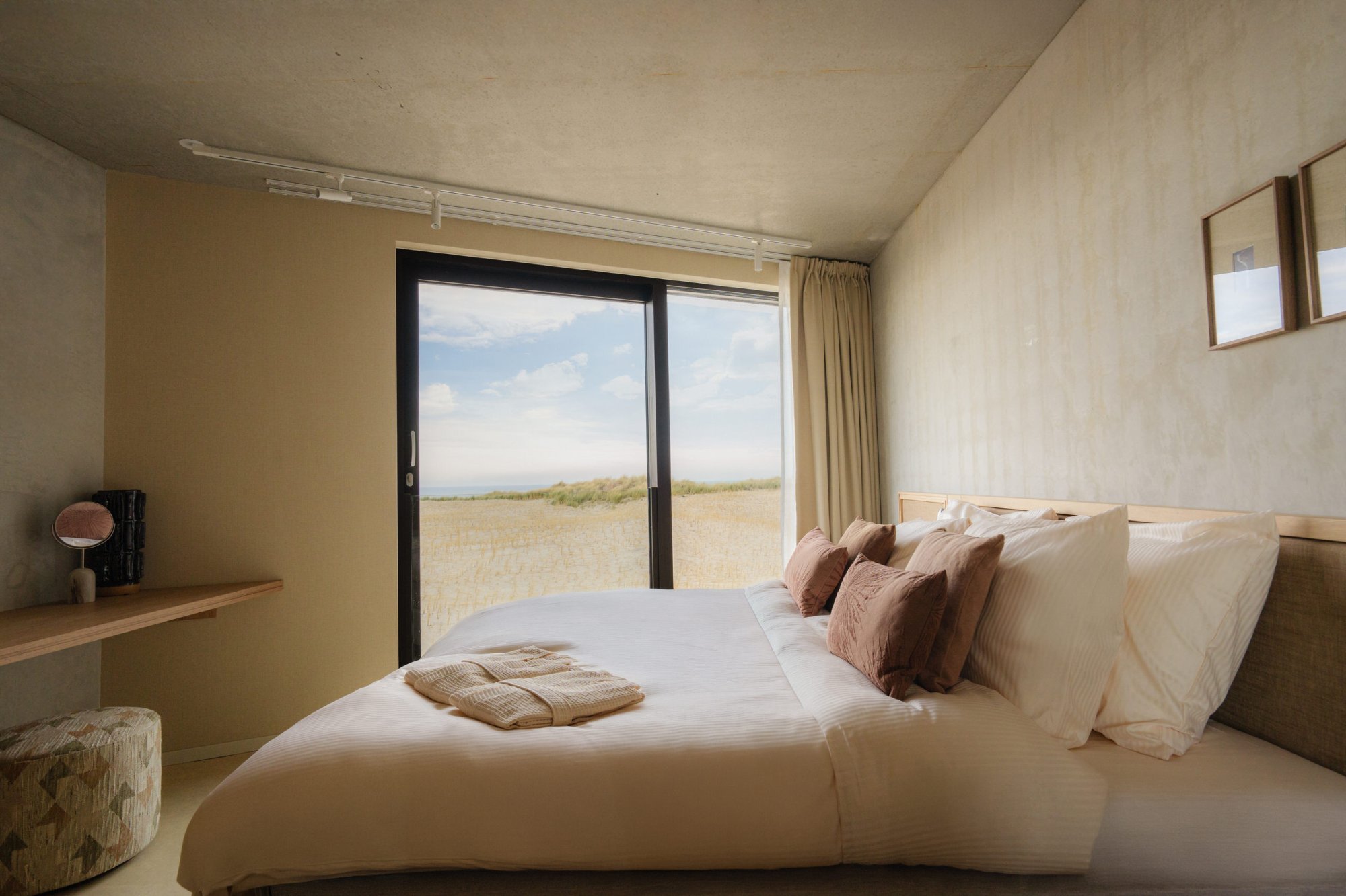 Lichte slaapkamer in duplex appartement met rustige, warme inrichting.