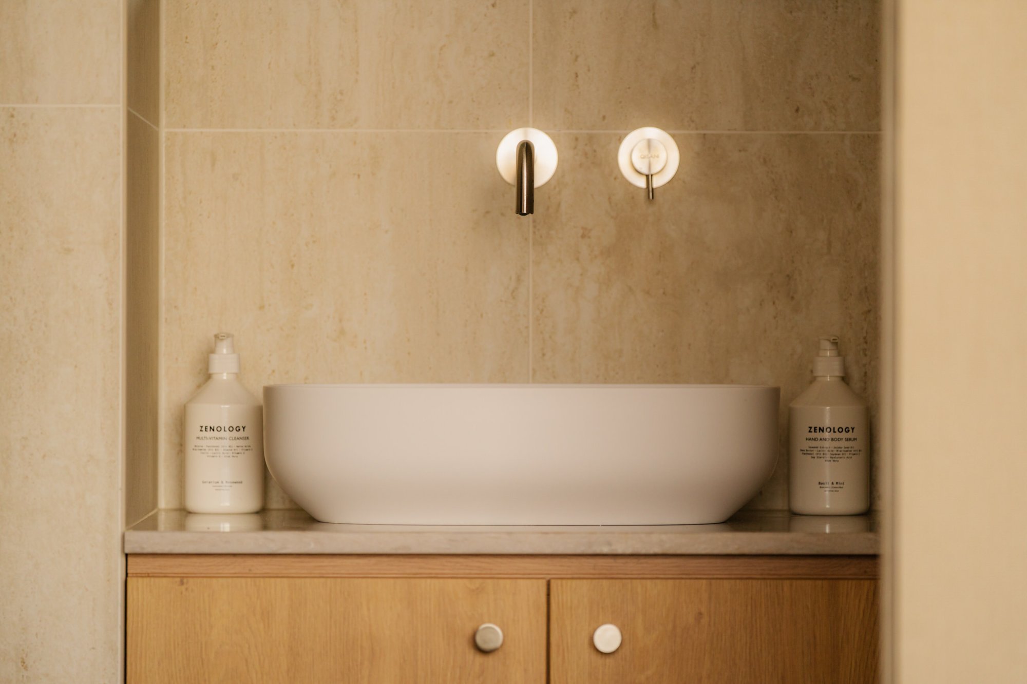 Wastafelmeubel met ronde spiegel in luxe badkamer van Elements.