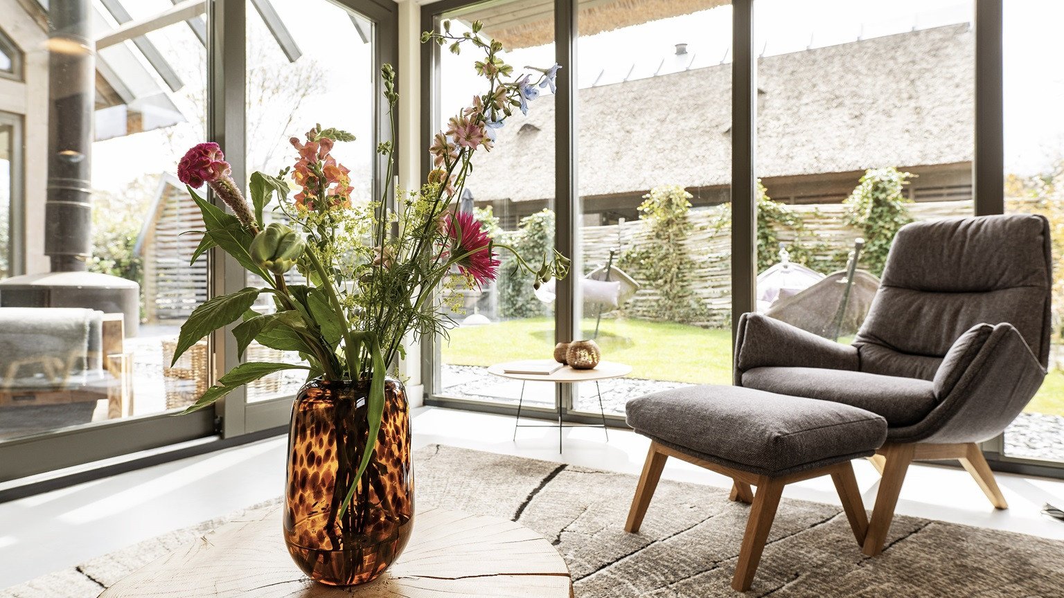 Lichte woonkamer in een vakantiehuis met zicht op de natuur.