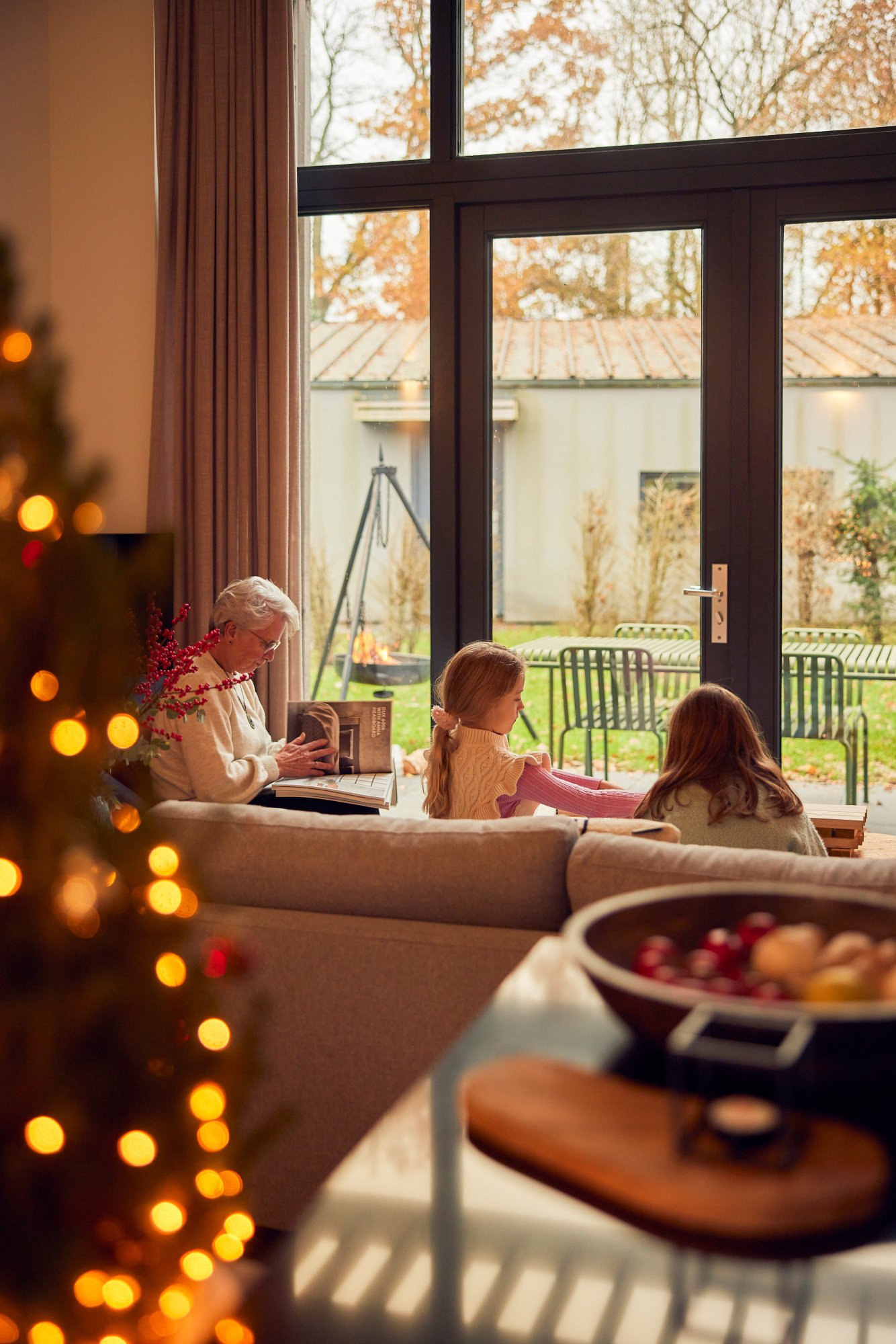 Familie samen in een vakantiehuis met kerstboom en winterse sfeer.