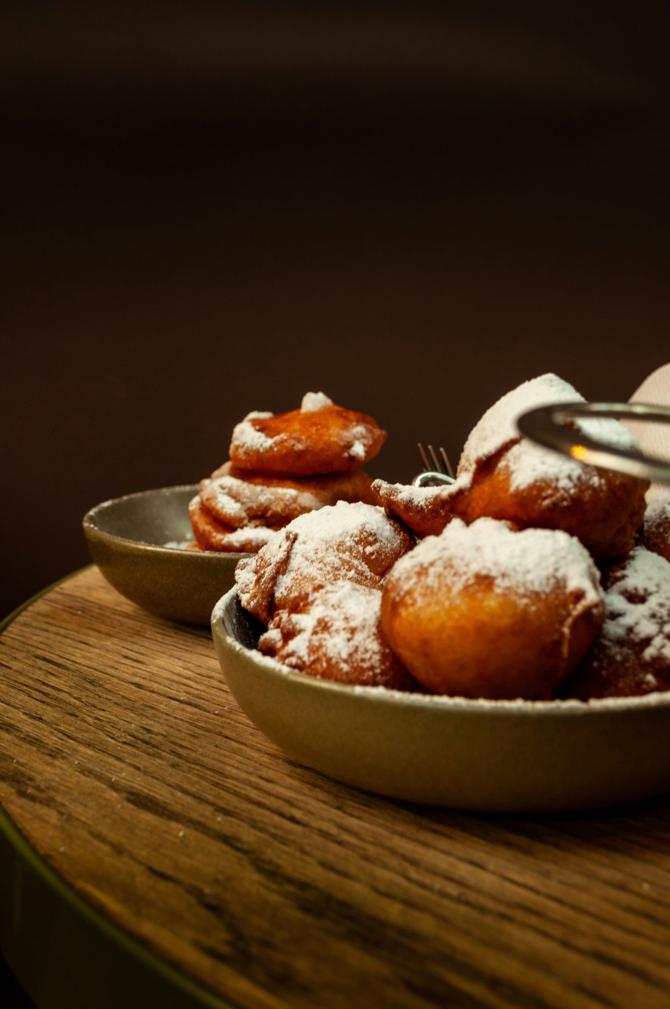 Oliebollen met poedersuiker op tafel tijdens oud en nieuw.